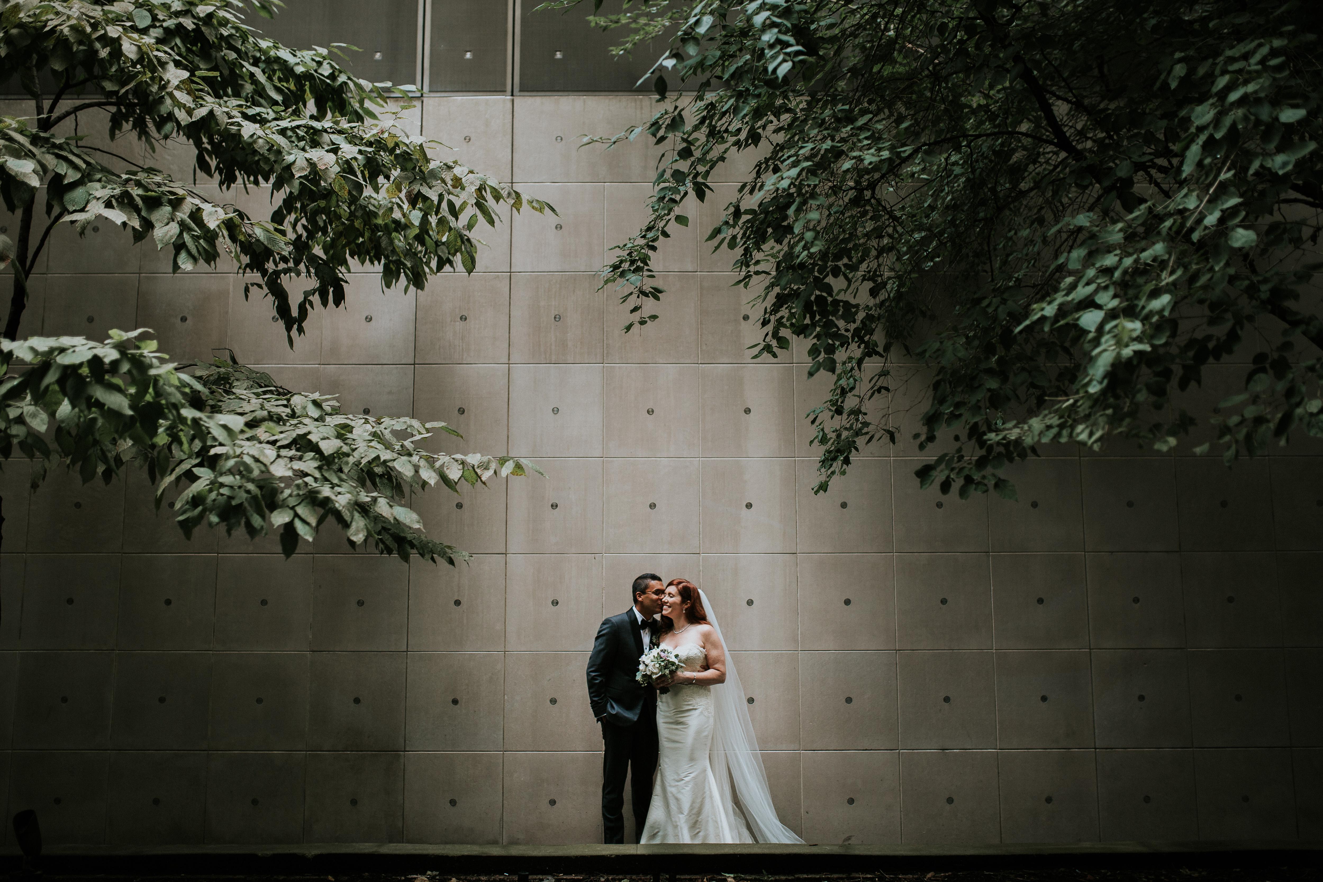 A couple poses for an intimate photo with the MCA facade serving as a backdrop